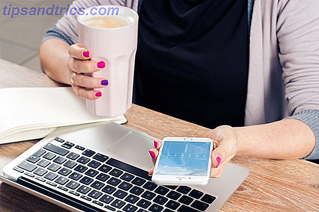 Kvinne drikker kaffe på telefon og Mac