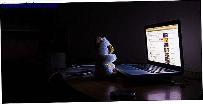 Animal en peluche devant l'ordinateur lumineux pour montrer la contrainte d'oeil d'ordinateur